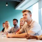 A group of post-graduate candidates in a boardroom.