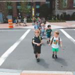 Kindergarten children group walking on crosswalk at Charles Street in Boston.