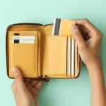 Person taking out a credit card from a wallet.