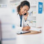 A pharmacist taking a call and listing a customer's order.