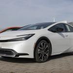 A used white Toyota Prius on display at a dealership.