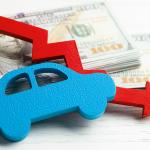 Figure of a car and declining arrow on top of U.S. banknotes.