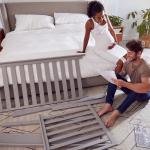 An expecting couple reading instructions on how to set up a cot.