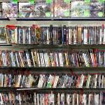 PlayStation game discs on display at a game store.