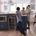 Parents prepare food as their children play around the kitchen.