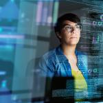 A young female computer programmer looking through data.