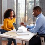 A young woman engaged in a discussion with a financial advisor in an office.
