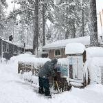 Mobile home owners shovel snow during a winter storm on March 02, 2024 in the Sierra Nevada mountains in Truckee, California.