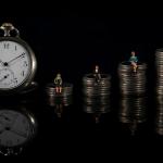 The concept of counting down to retirement illustrated by an increasing stack of coins with miniature people sitting on each one, with a clock placed on the side.