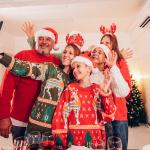 A six-member family in their Christmas hats and outfits squeezing in for a selfie.