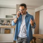A man at home talking on the phone.