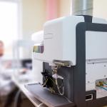 A focus on a microwave plasma atomic emission spectrometer (MPAES) a scientist is working with in a laboratory.