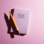 A pink 2026 planner with a pencil against a pink background.