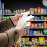 A person reviewing their receipt in the supermarket to track prices