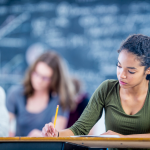 A student writing at a desk.