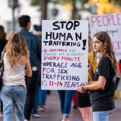 Young adult holding “Stop Human Trafficking” sign at awareness demonstration.