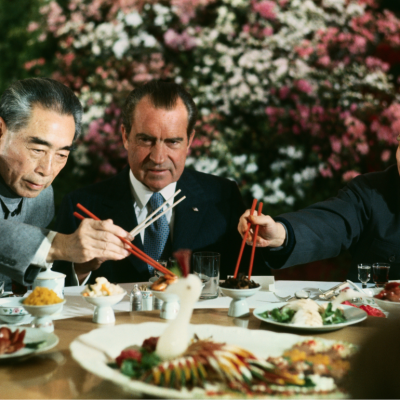 President Nixon eats with Premier Zhou En-lai and Zhang Chun-chiao at a farewell banquet.