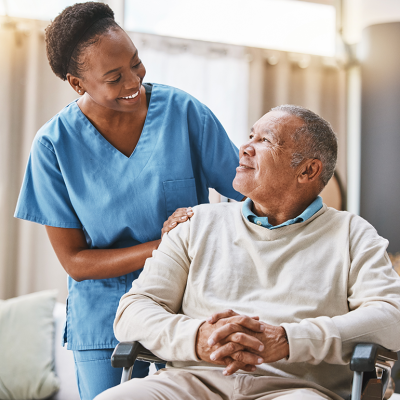 Nurse assisting a man in wheelchair.