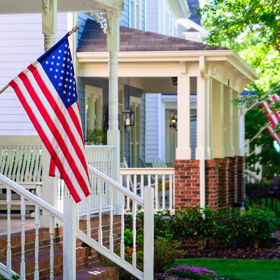 A line of suburban homes with American Flags.