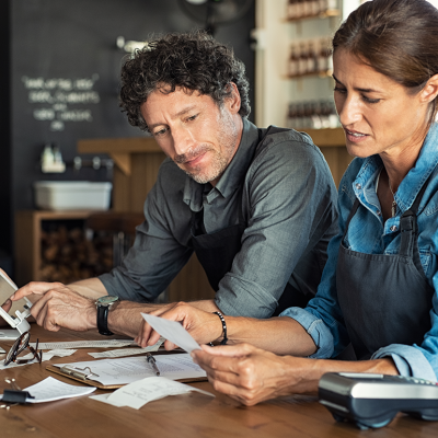 Cafe owners looking at bills and reports.