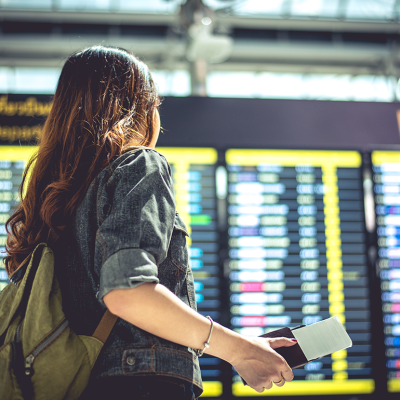 A person looking at departures board in airport.