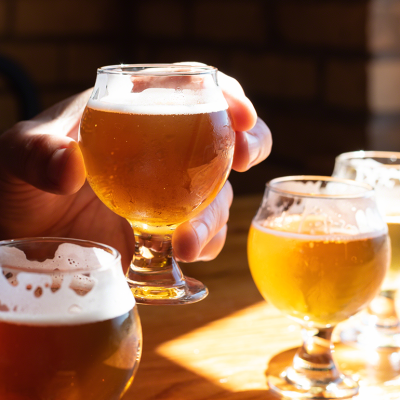 Person holding glass of beer at sampling.