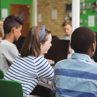 Students in a classroom listen to their teacher
