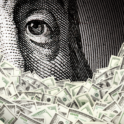 Close up of Benjamin Franklin portrait with hundred dollar bills in the foreground