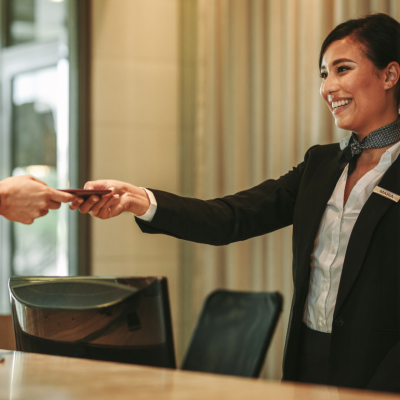 Receptionist at the hotel giving a guest a key.