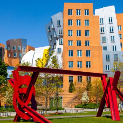 Red metal sculpture by artist Mark di Suvero and the iconic Stata Center by architect Frank Gehry on the MIT campus in Cambridge, Massachusetts.