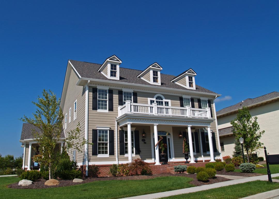 Large tan two-story new construction home styled to look like a historic house in Carmel, Indiana.