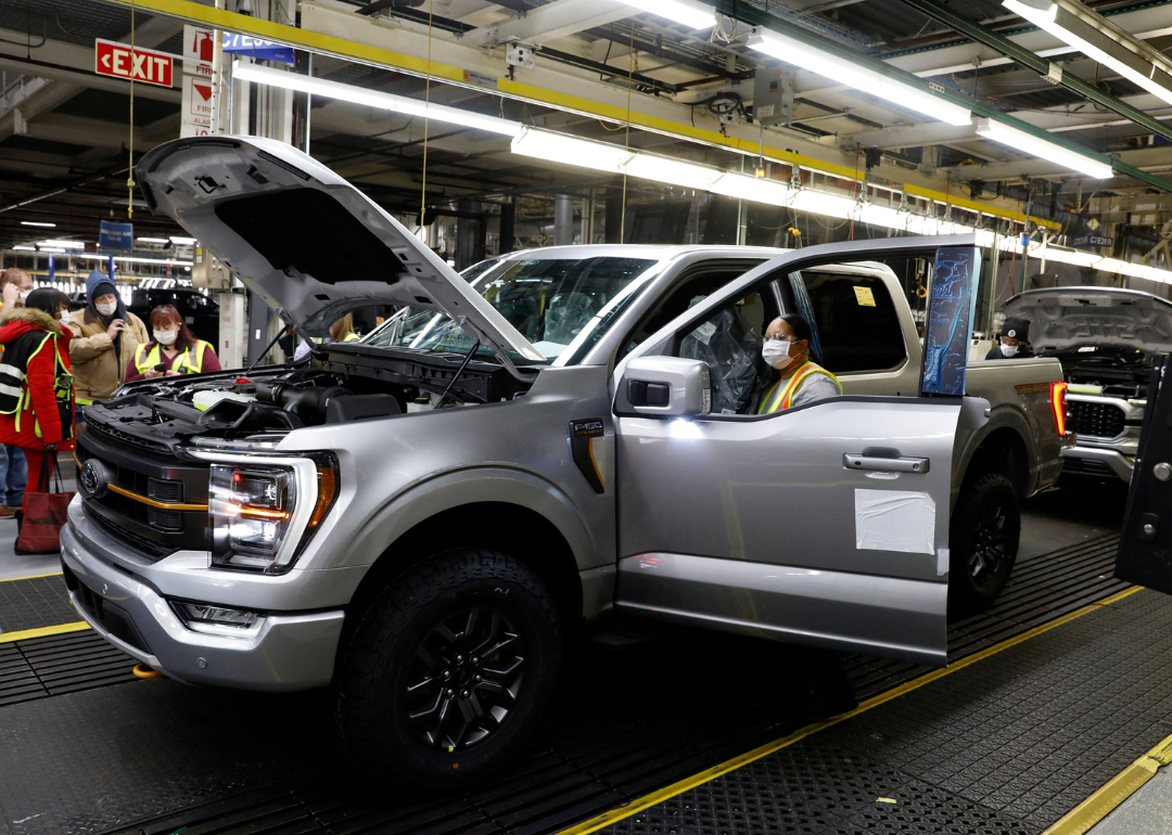 Workers assemble cars at a Ford assembly plant.