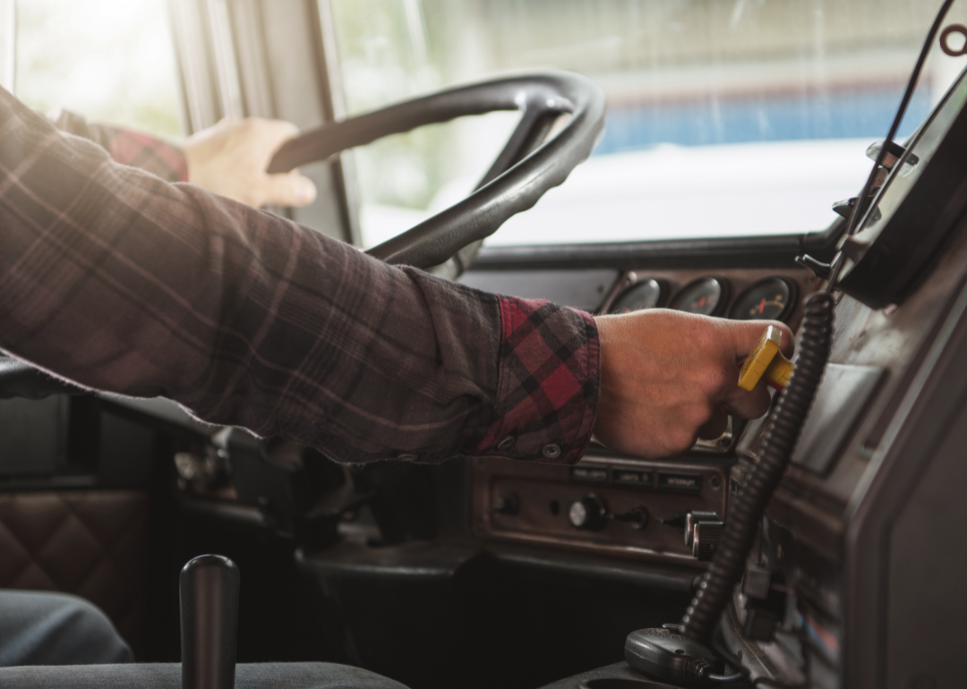Trucker behind truck steering wheel.