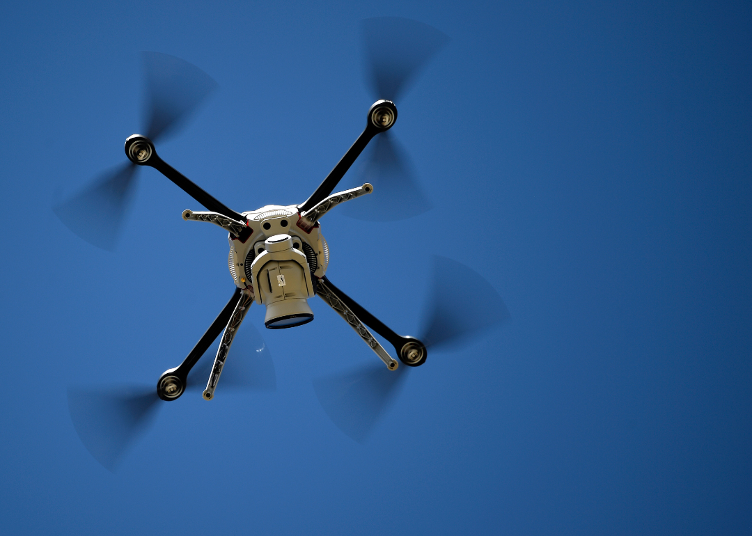 A police drone hovering in the blue sky.