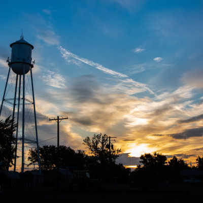 A water tower in a small American town seen at sunset