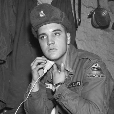 A portrait of Elvis Presley in his military uniform shaving at the maneuver camp Grafenwoehr in Germany.