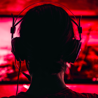 A woman wearing headphones and playing a video game.