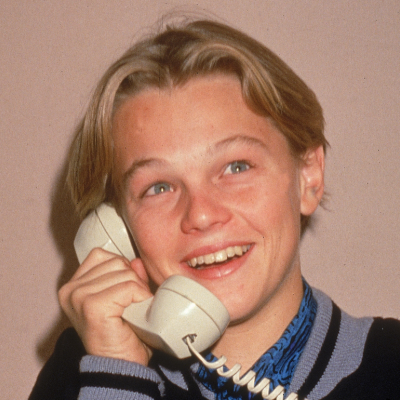 A young Leonardo DiCaprio poses for a picture while talking on a telephone, circa 1989