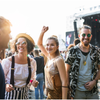 A group of young men and women smiling and dancing outdoors
