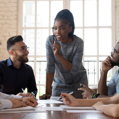 a female Black executive discusses a work topic with a diverse staff