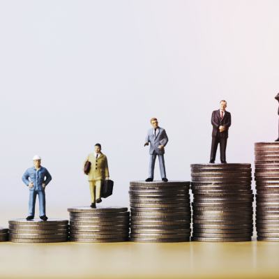 An image showing steadily growing piles of coins topped with small figures of workers dressed to 'match' a perceived income level