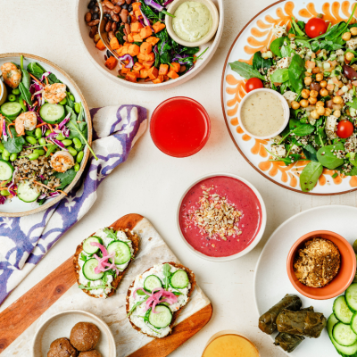 An overhead view of a variety of plant-based foods on a white surface.