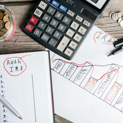 On a desk, a calculator, a handwritten financial plan, and a jar of coins