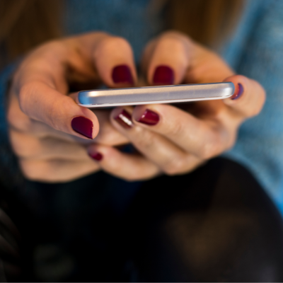 A cellphone being operated by two hands.