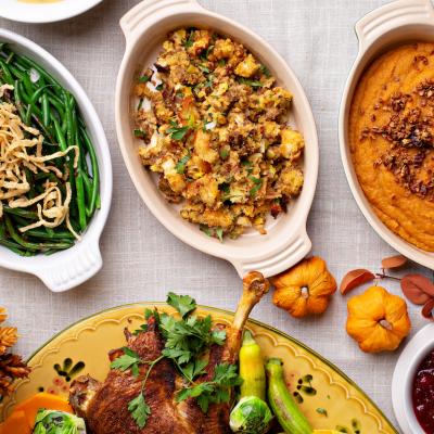 Casserole dishes of green beans, stuffing, and sweet potatoes.