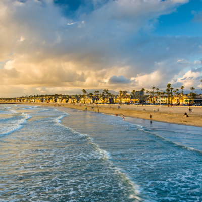 Waves in the Pacific Ocean and view of the beach at sunset, in Newport Beach, California