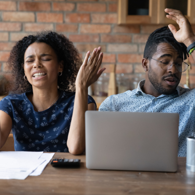 A young Black couple is expressing frustration over financial documents