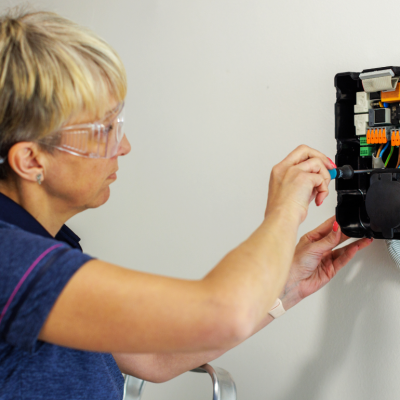 woman installing EV charger at home