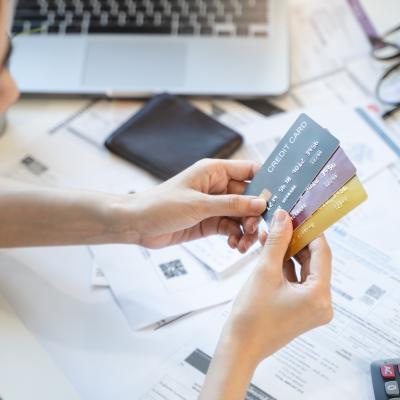 woman looking at credit cards with bills in the background 