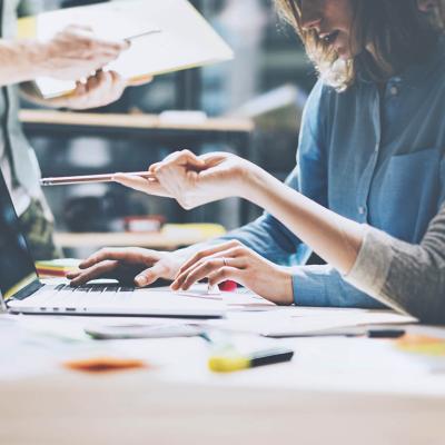 close up of people working, two women looking at computer